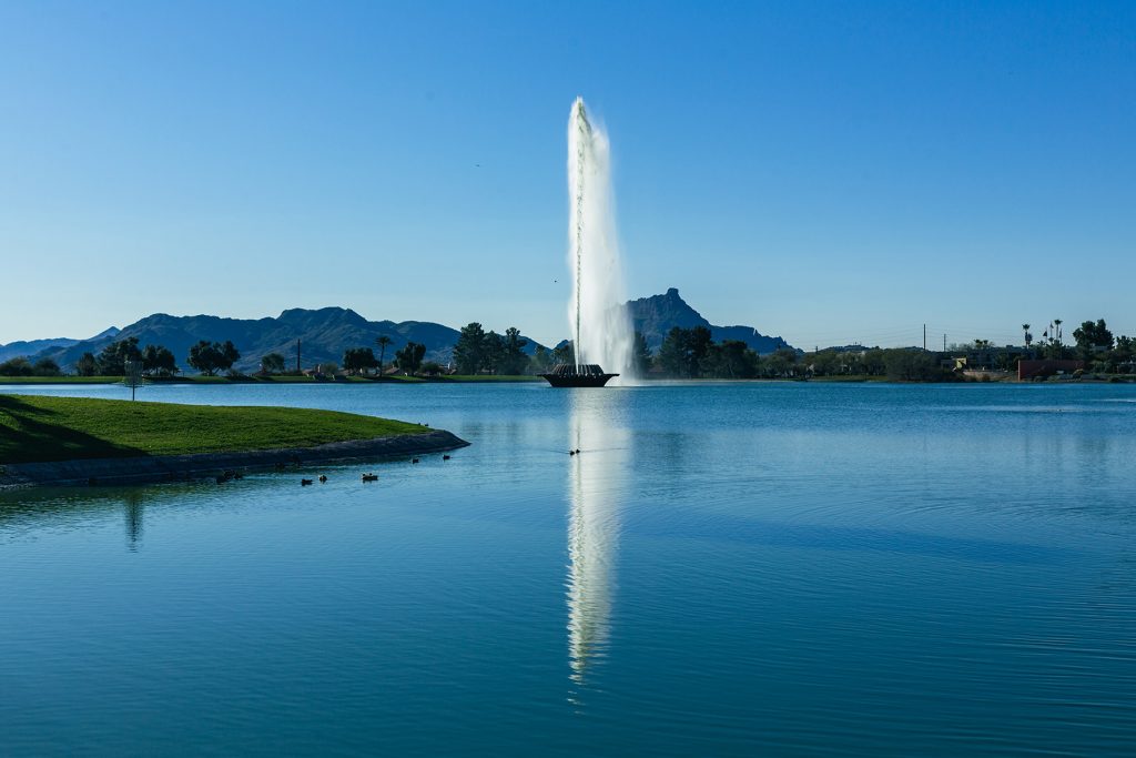 View of Fountain Hills, Arizona with the iconic fountain, lush green parks, and residential areas against a Sonoran Desert backdrop.