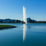 View of Fountain Hills, Arizona with the iconic fountain, lush green parks, and residential areas against a Sonoran Desert backdrop.