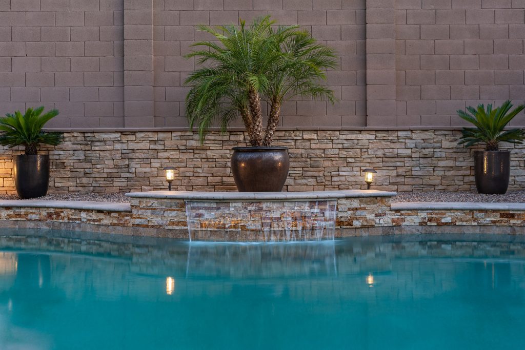 Inviting backyard oasis with a refreshing pool, surrounded by lush greenery, creating a serene and relaxing outdoor space.