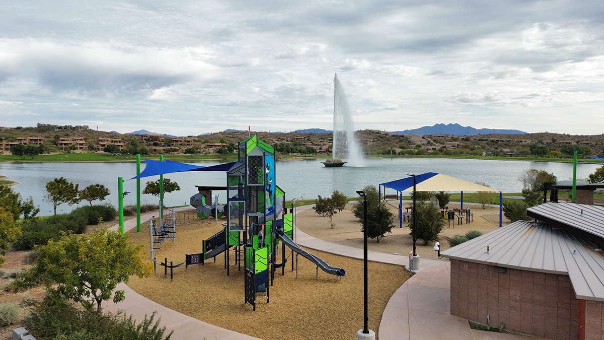 Scenic view of Fountain Park in Fountain Hills, featuring the iconic fountain, serene lake, lush greenery, and a playground.