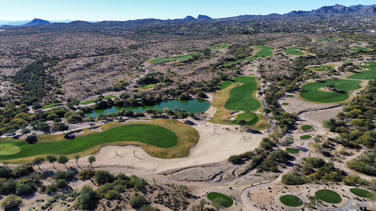 A stunning view of We-Ko-Pa Golf Course, featuring manicured greens, picturesque desert terrain, and breathtaking mountain vistas.